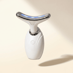 White facial conotour wand with a silver top on a beige background