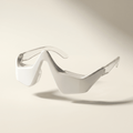 Wearable red light therapy glasses on a beige background